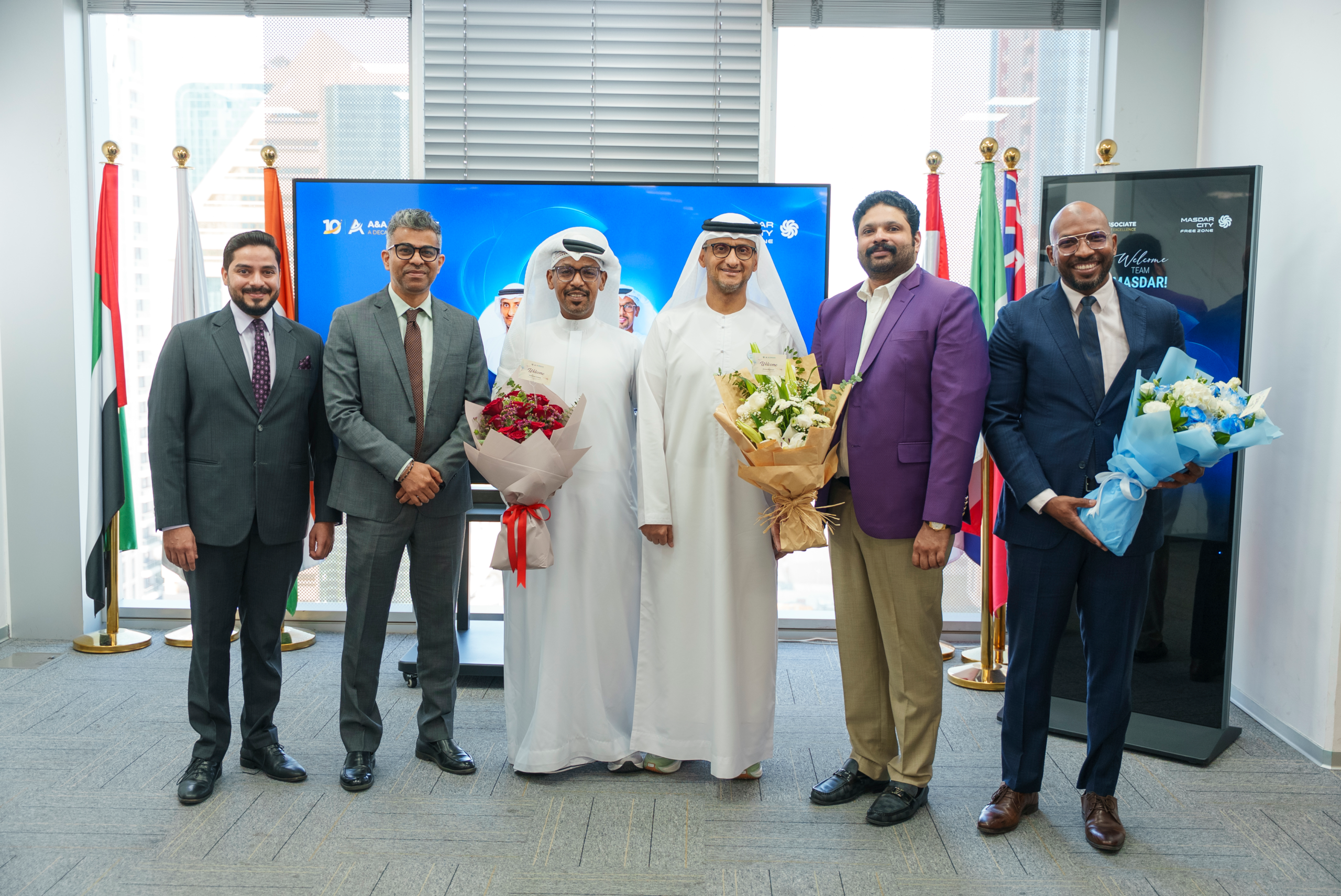 A&A Business Setup Experts team welcoming Masdar City Abu Dhabi officials at their Dubai office — official group photograph with flowers